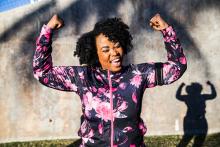 Image of mature woman smiling and flexing her biceps